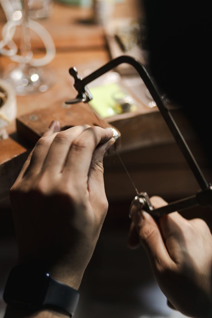 Detailed image of artisan hands crafting jewelry, showcasing precision and craftsmanship.