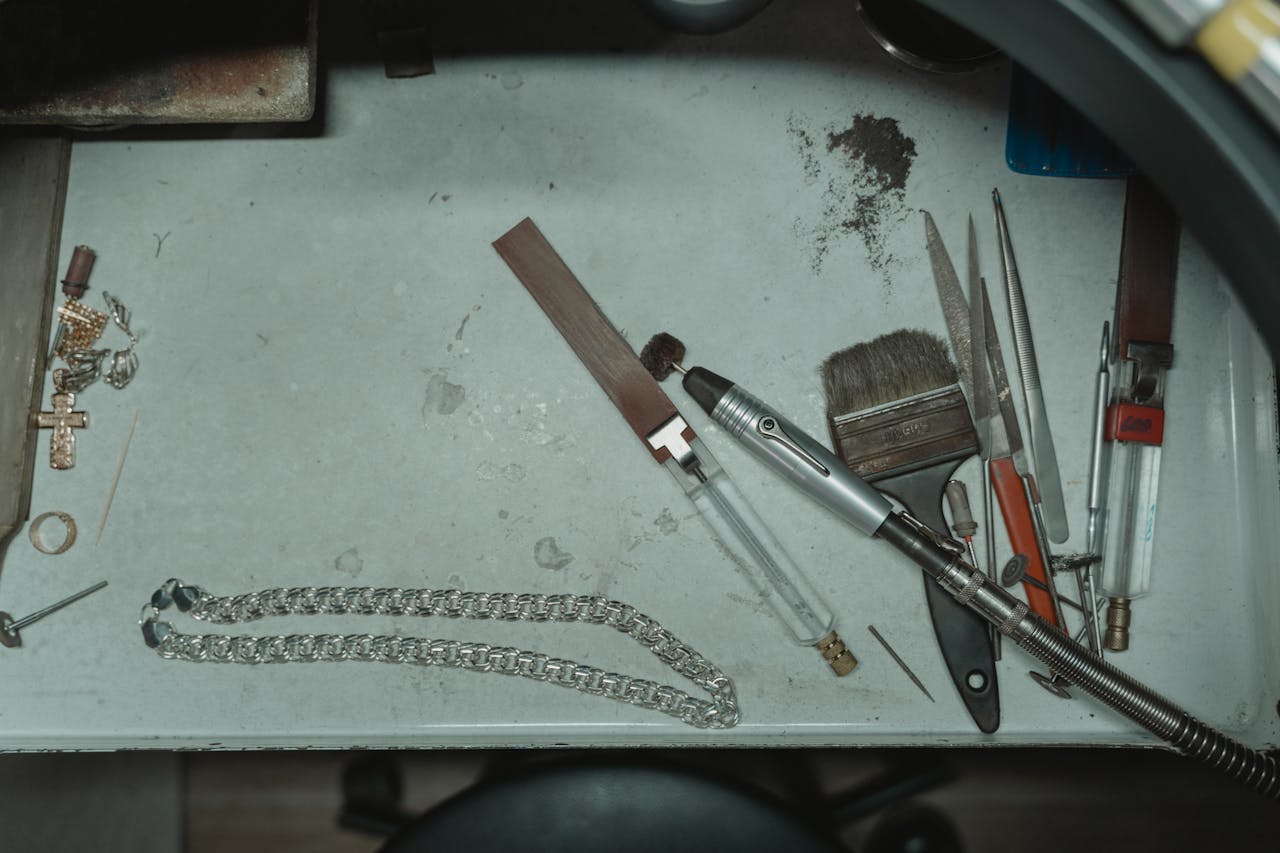 A detailed view of a jewelry maker's workspace showcasing tools and jewelry components.